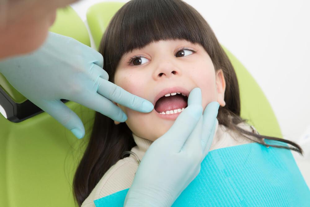 Young girl having her teeth examined during an early orthodontic checkup
