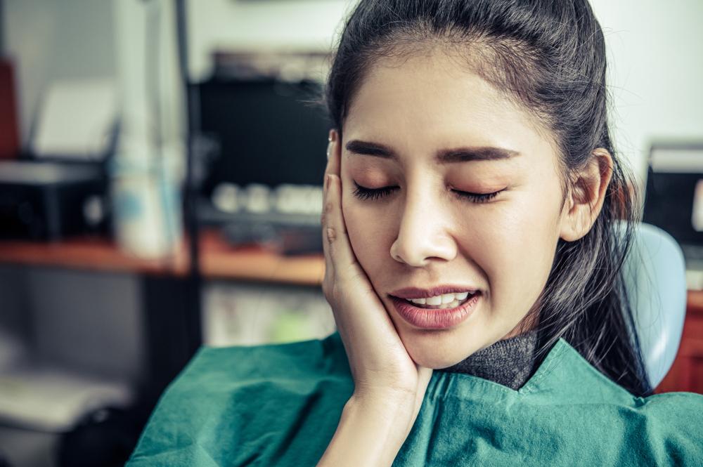 woman with a toothache cupping her cheeks