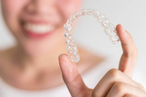 a person holding Invisalign aligners