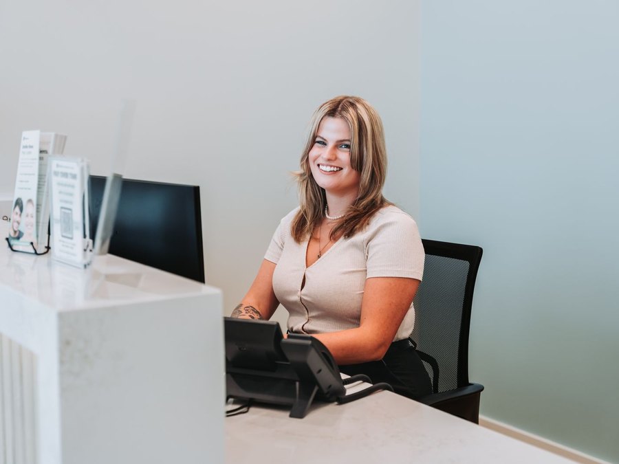Front desk team member greeting visitors at Cape Fear Orthodontics in Leland, NC